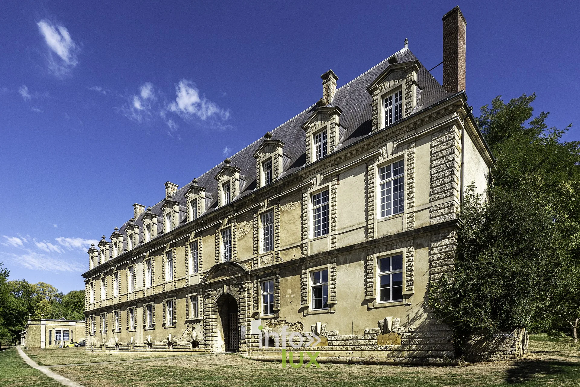 Bâtiment classique à lucarnes et toiture d’ardoise au pied du château fort de Sedan