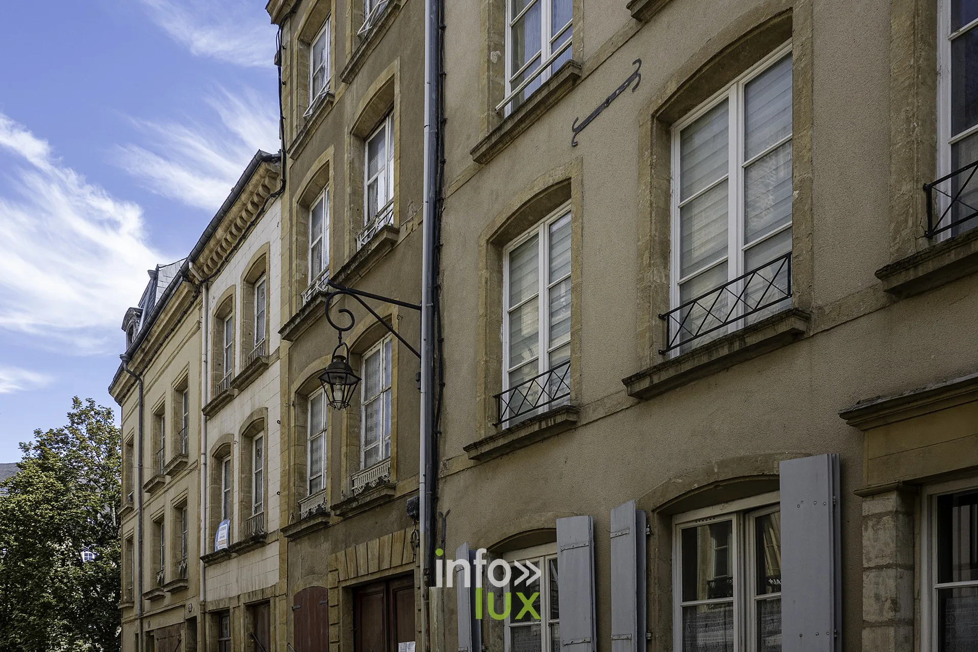 Façades d’immeubles à balcons en fer forgé dans une rue de Sedan