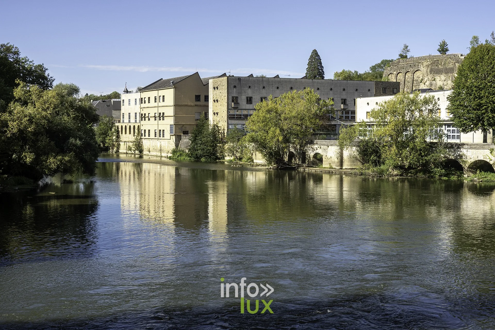 La Meuse à Sedan, rives bâties et verdure sous un ciel bleu