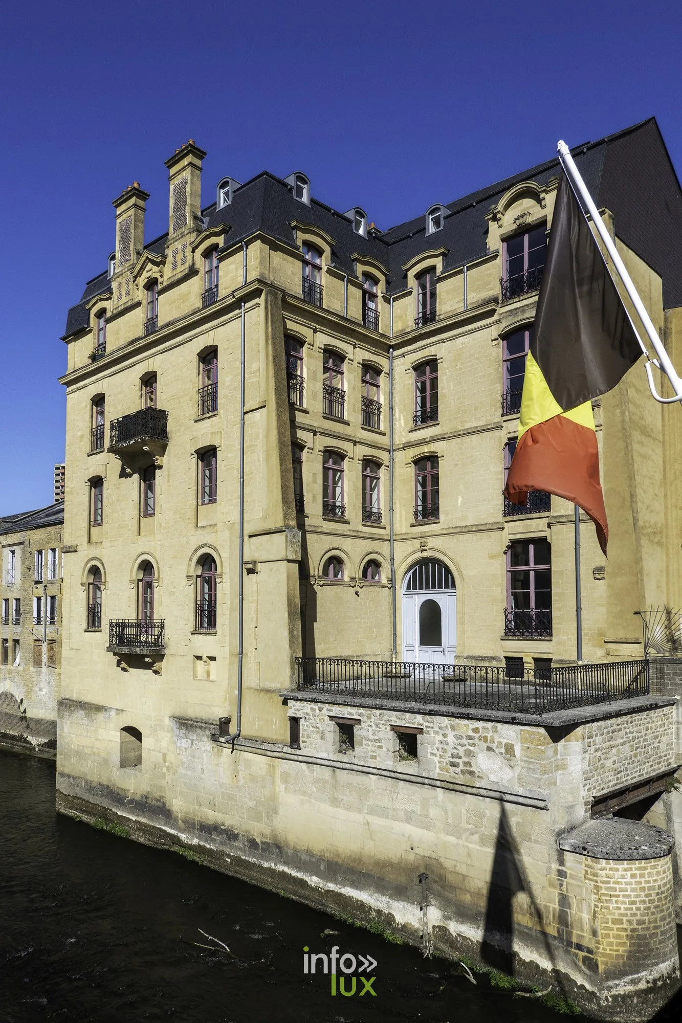 Immeuble ancien au bord de l’eau avec drapeau, Sedan