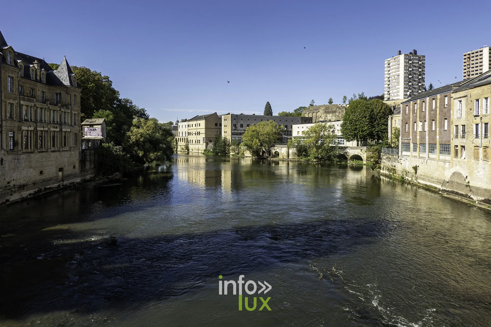 La Meuse à Sedan, rives et immeubles sous un ciel bleu