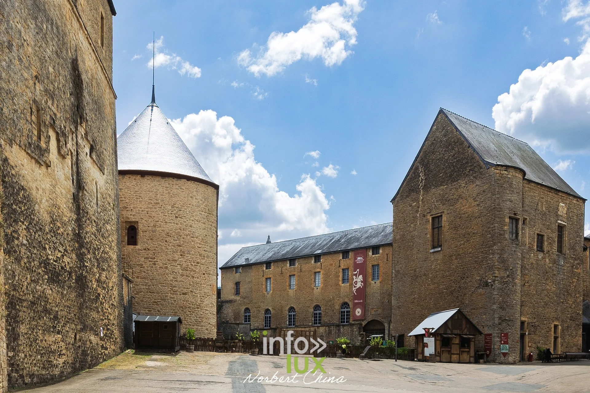 Cour du château fort de Sedan avec tour ronde à toit conique et bâtiments en pierre