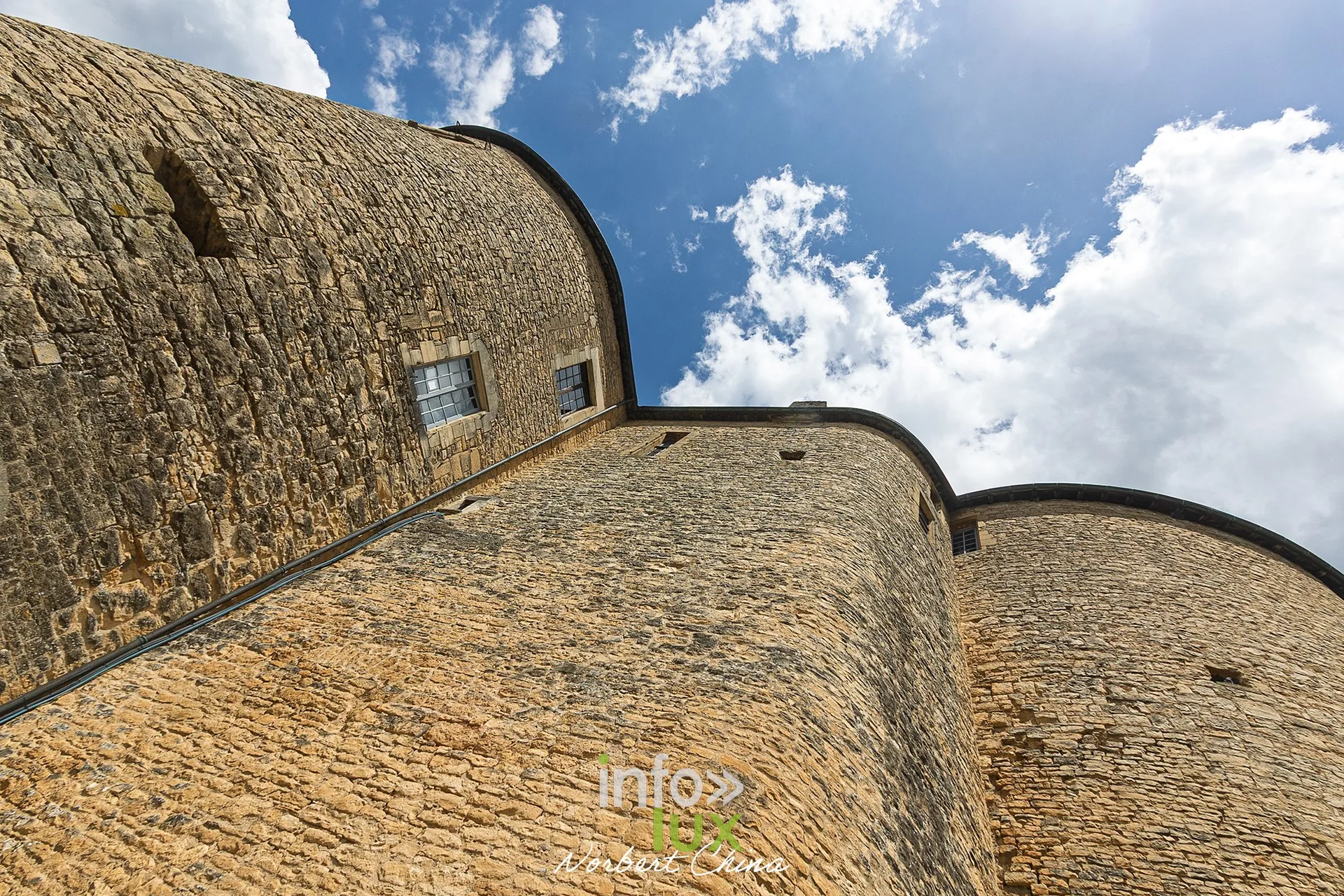 Murs courbes des tours du château fort de Sedan en contre-plongée sous un ciel nuageux