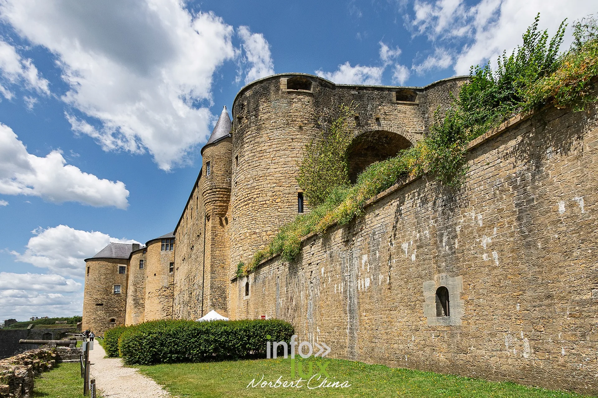 Murailles et tours du château fort de Sedan au-dessus des fossés, ciel nuageux