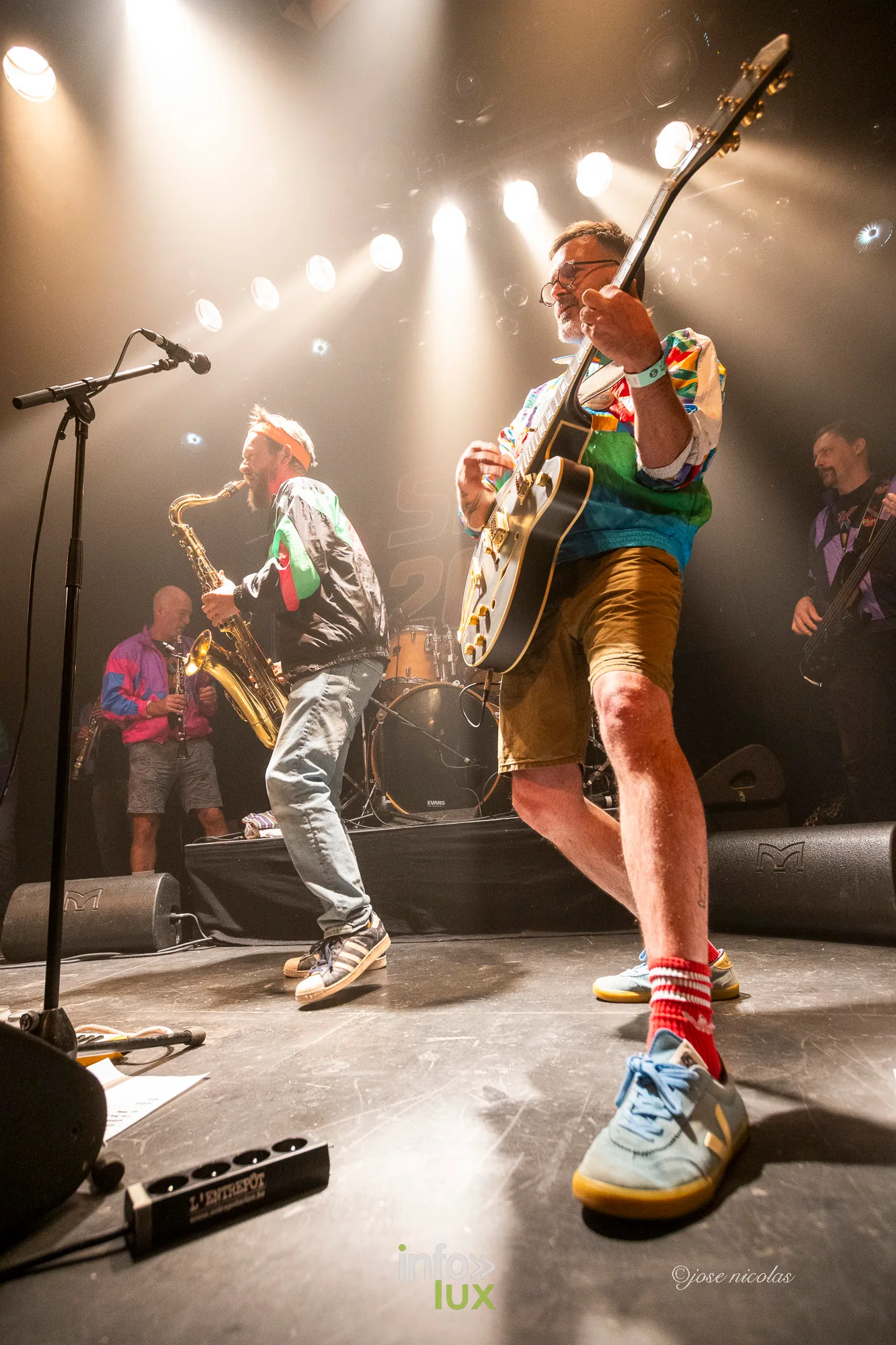 Un guitariste de SKA 2000 en mouvement au premier plan, L’Entrepôt d’Arlon, 25 septembre 2026