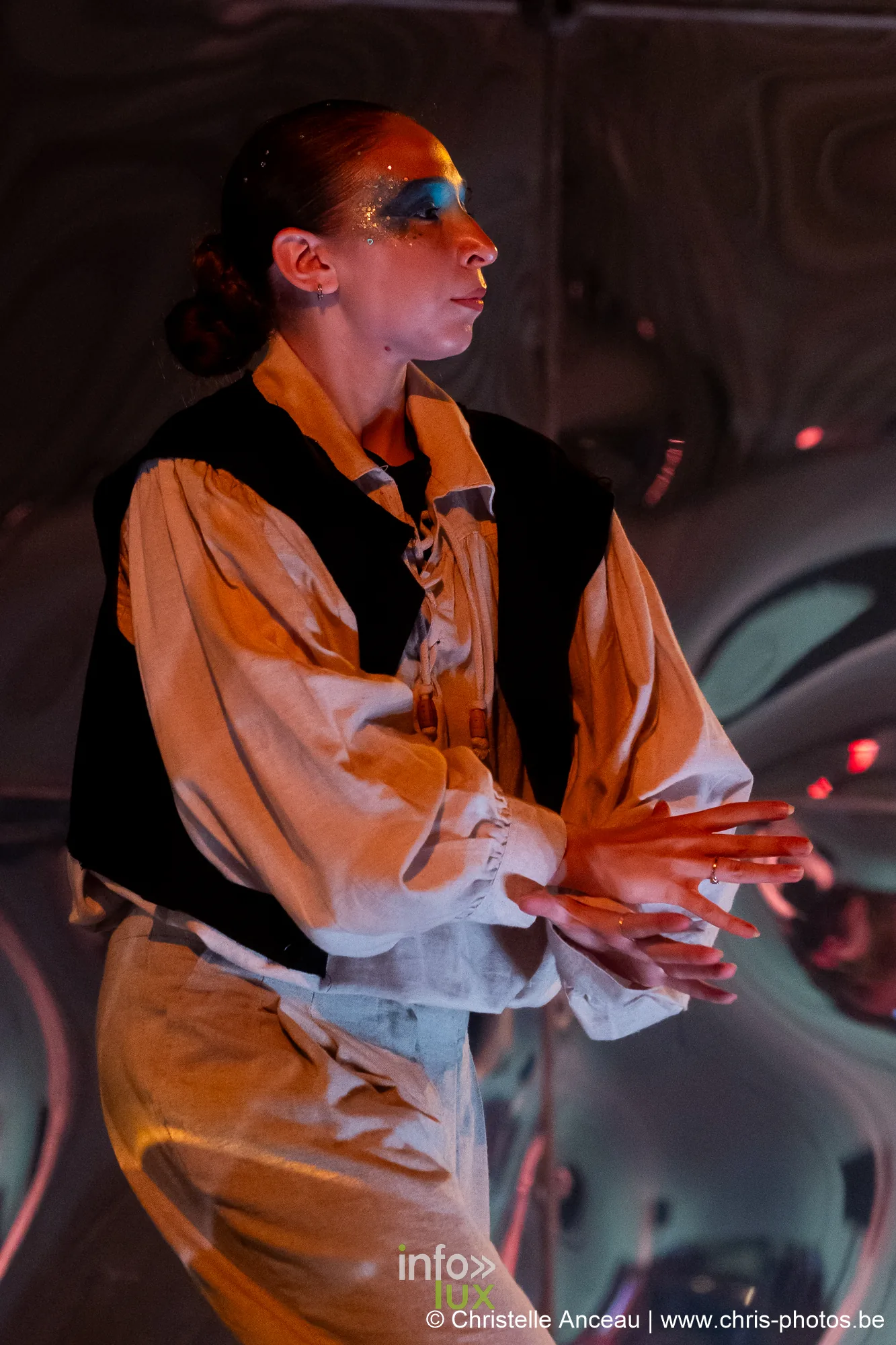 Comédien en gilet noir, les mains jointes, devant le miroir déformant du spectacle Monte-Cristal à Seraing