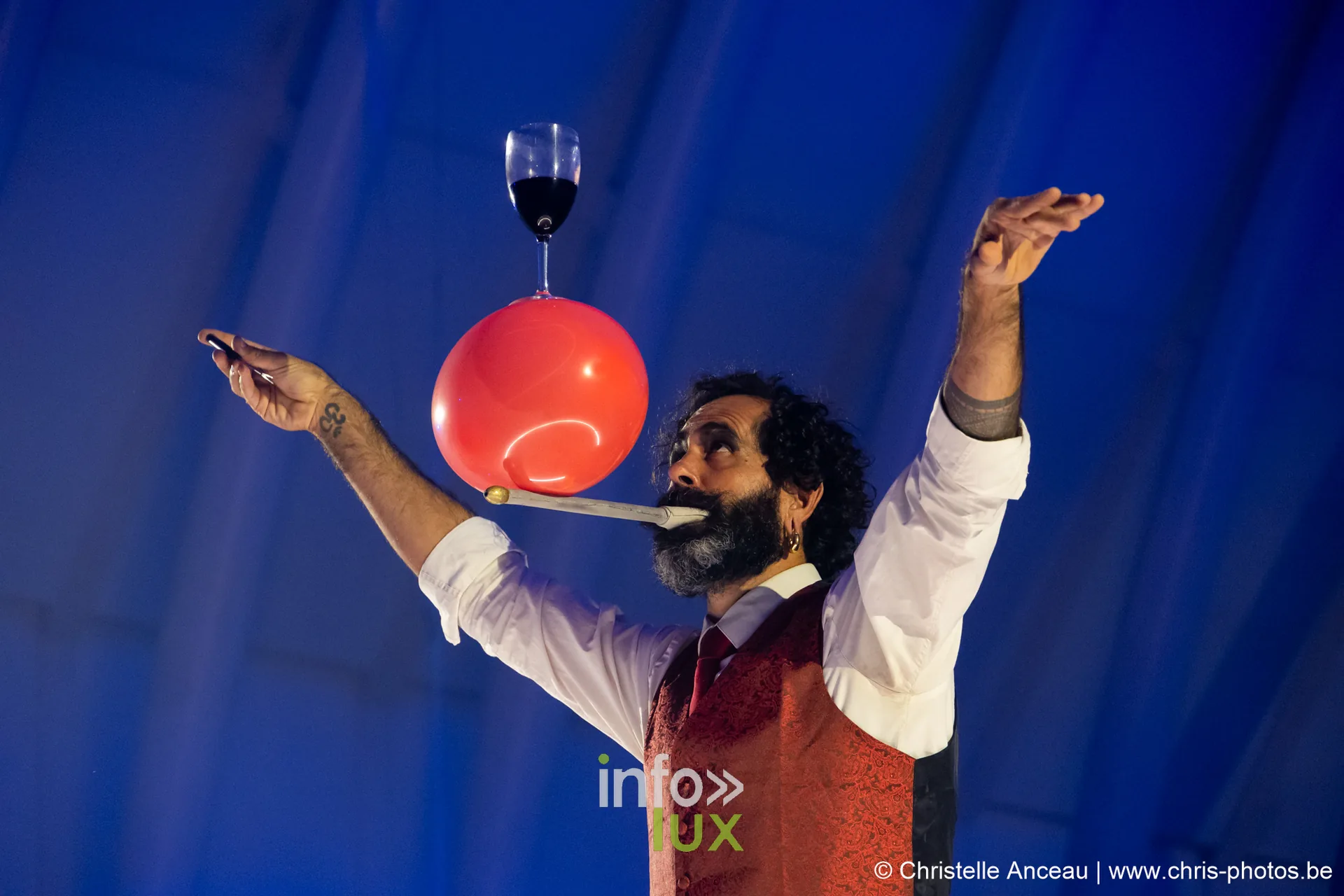 Artiste tenant en équilibre un verre de vin sur un ballon posé sur sa bouche, spectacle Monte-Cristal à Seraing