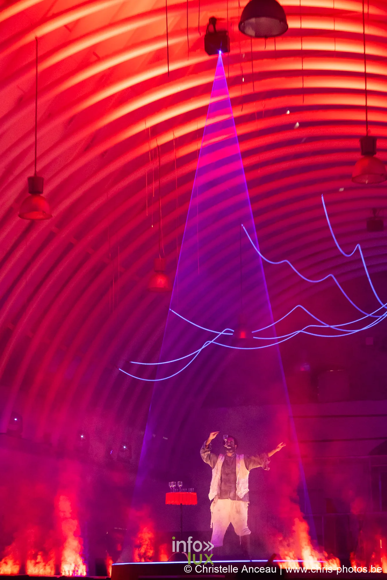 Scène baignée de rouge avec un comédien seul sous une projection, séquence Les Fours brûlent du spectacle Monte-Cristal