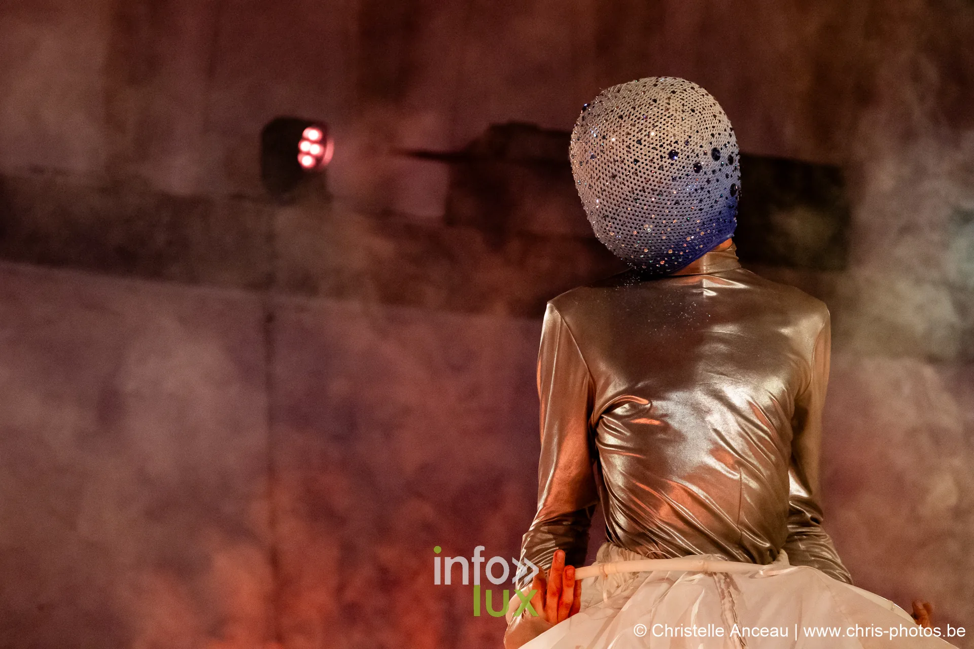 Personnage de dos en cagoule pailletée et costume doré dans la fumée, spectacle La Légende du Comte de Monte-Cristal