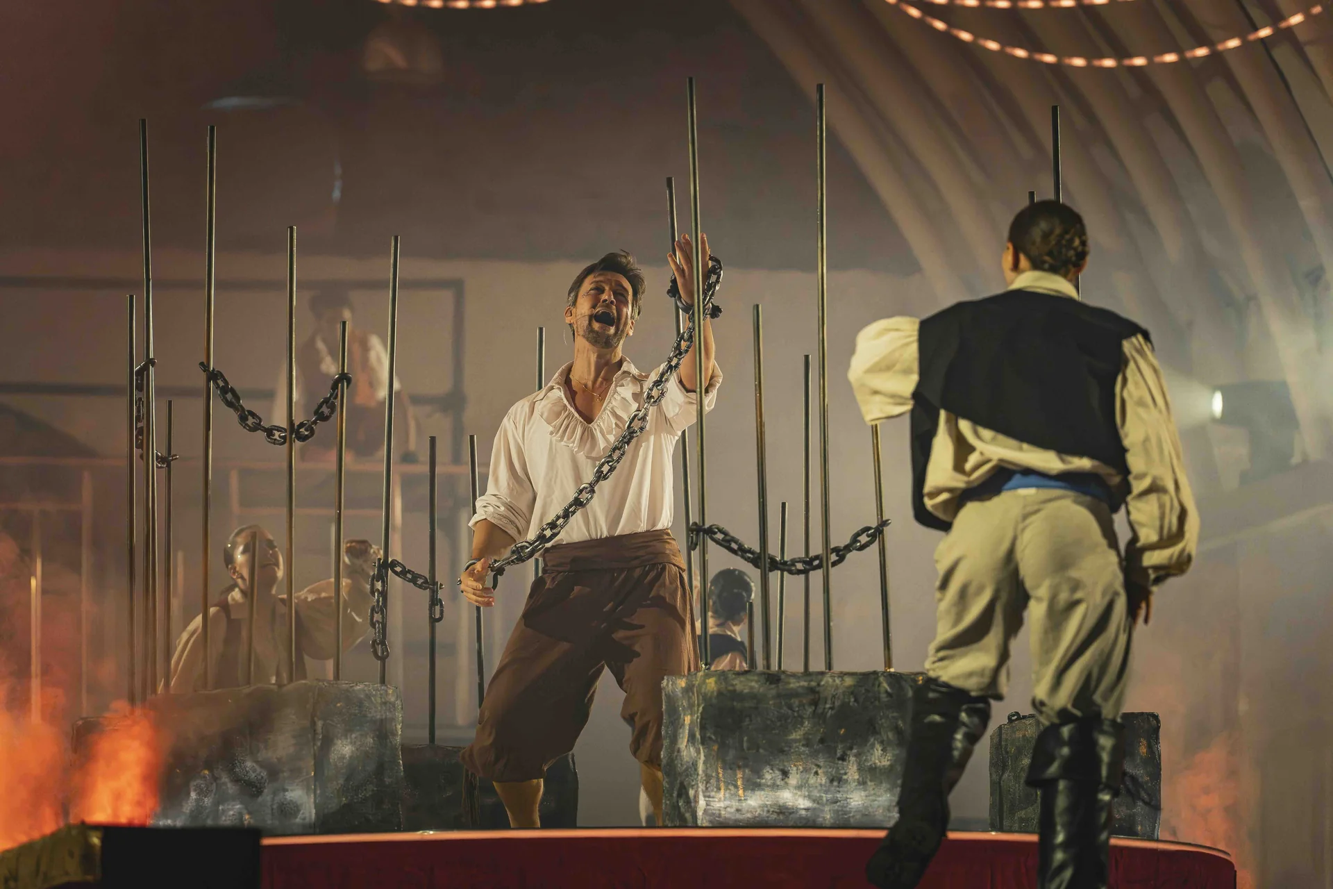 Deux comédiens enchaînés, dos à dos, dans la scène de prison du spectacle La Légende du Comte de Monte-Cristal au Val Saint-Lambert