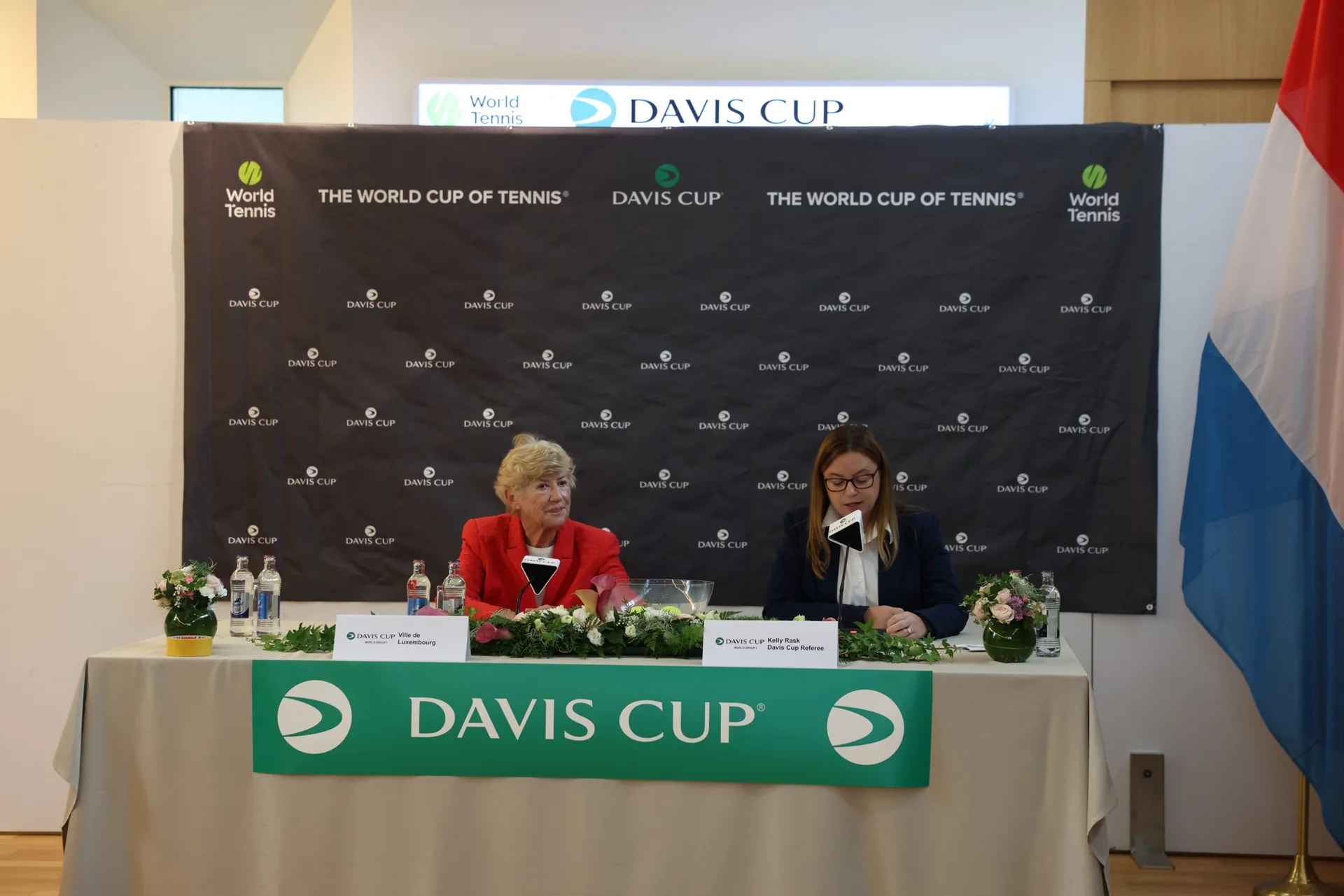 Table officielle Davis Cup du tirage au sort Luxembourg Hongrie avec deux officielles devant le panneau World Cup of Tennis