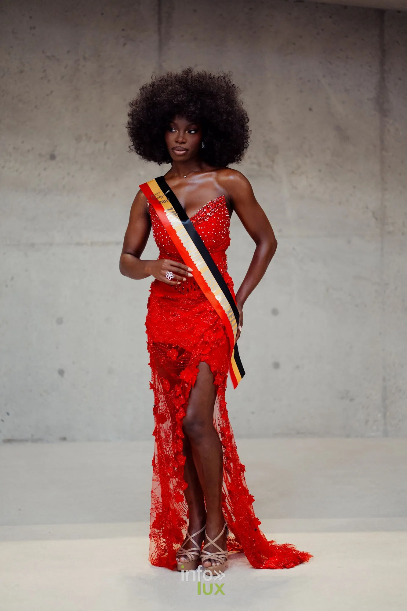 Delphine pose en robe rouge avec son écharpe de Première Dauphine
