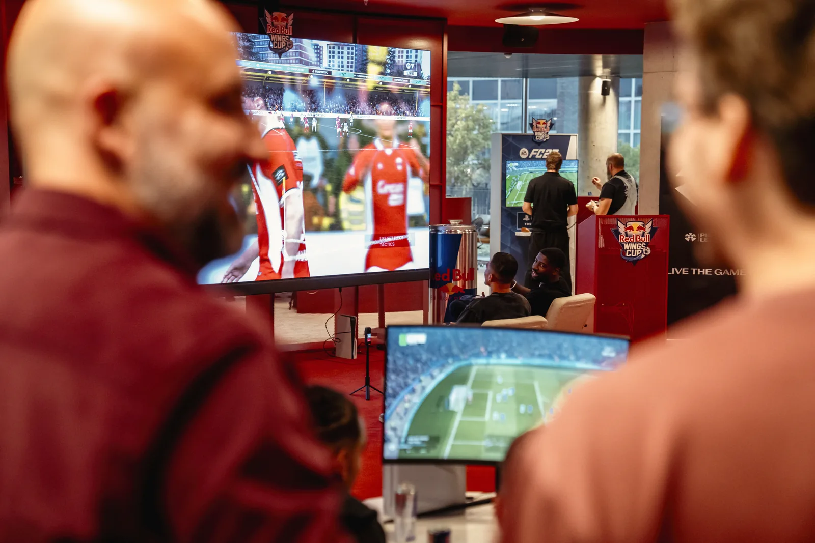 Échange entre invités devant les écrans de jeu à Bruxelles, lors du lancement belge d’EA SPORTS FC 27 et de la Red Bull Wings Cup, le 23 septembre 2026
