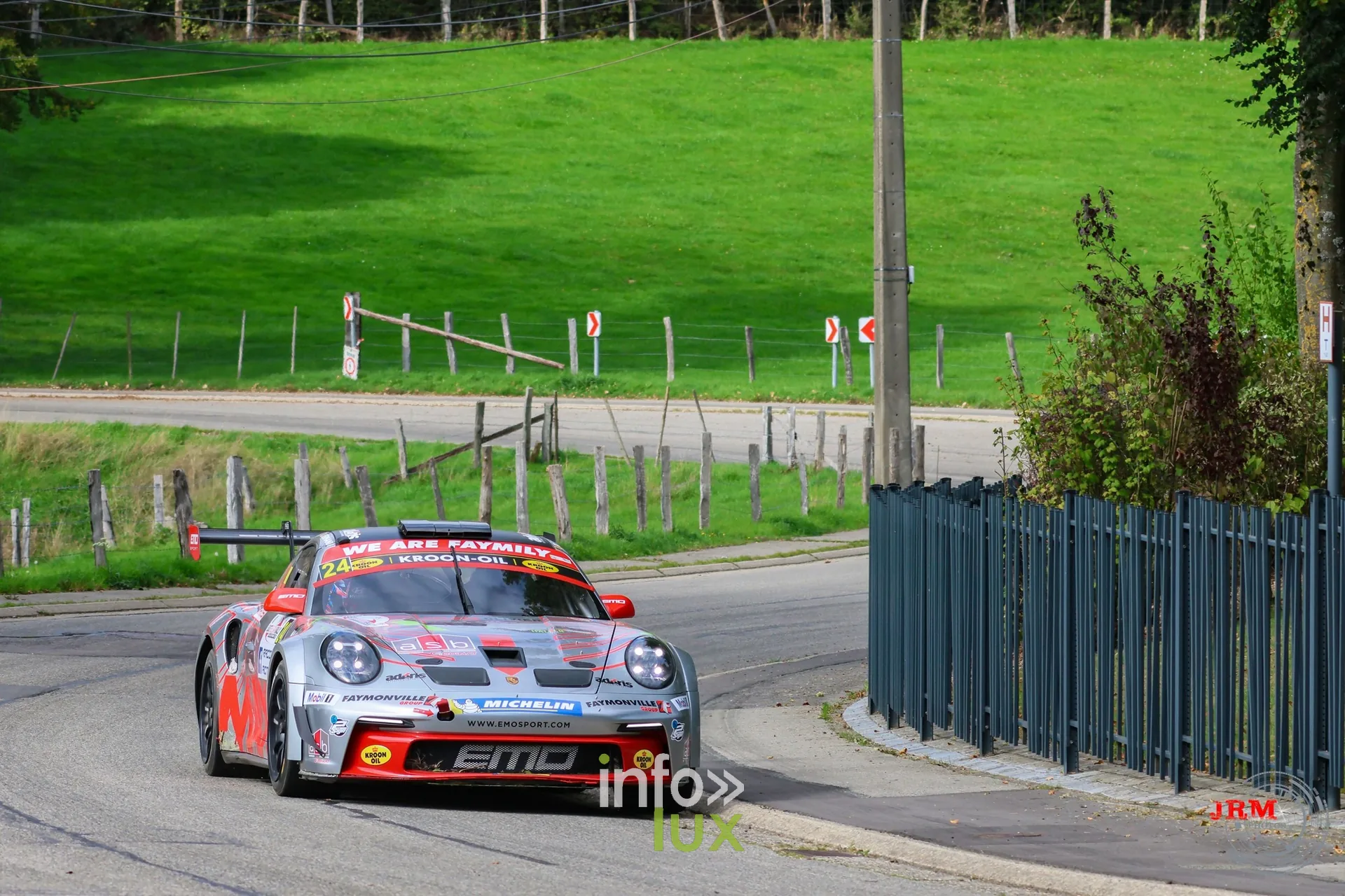 Porsche 911 GT3 de rallye grise et rouge dans une épingle en village, East Belgian Rally 2026