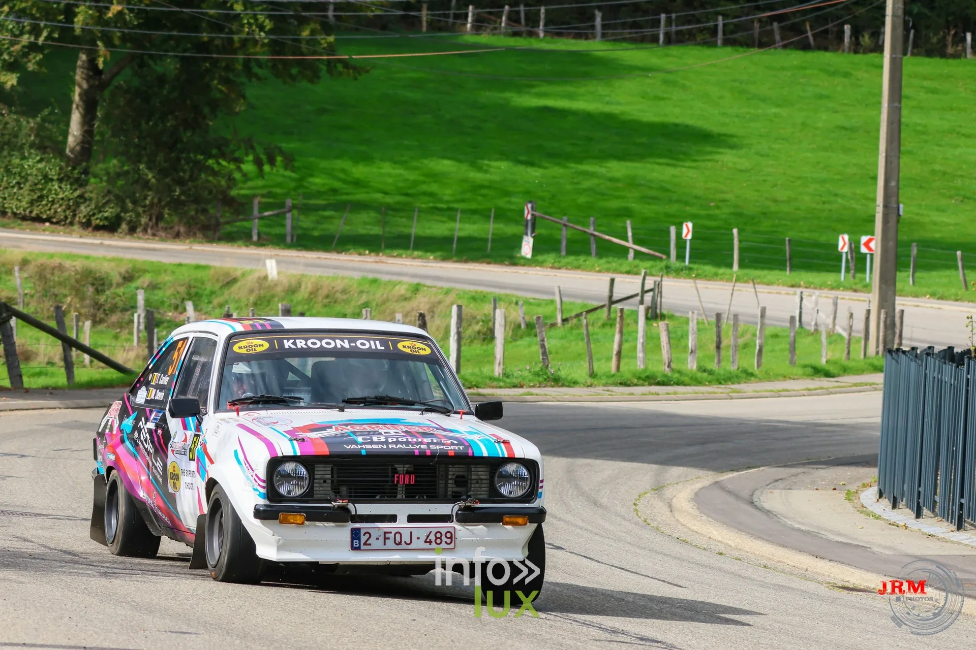 Ford Escort blanche aux couleurs vives dans une épingle en village, East Belgian Rally 2026