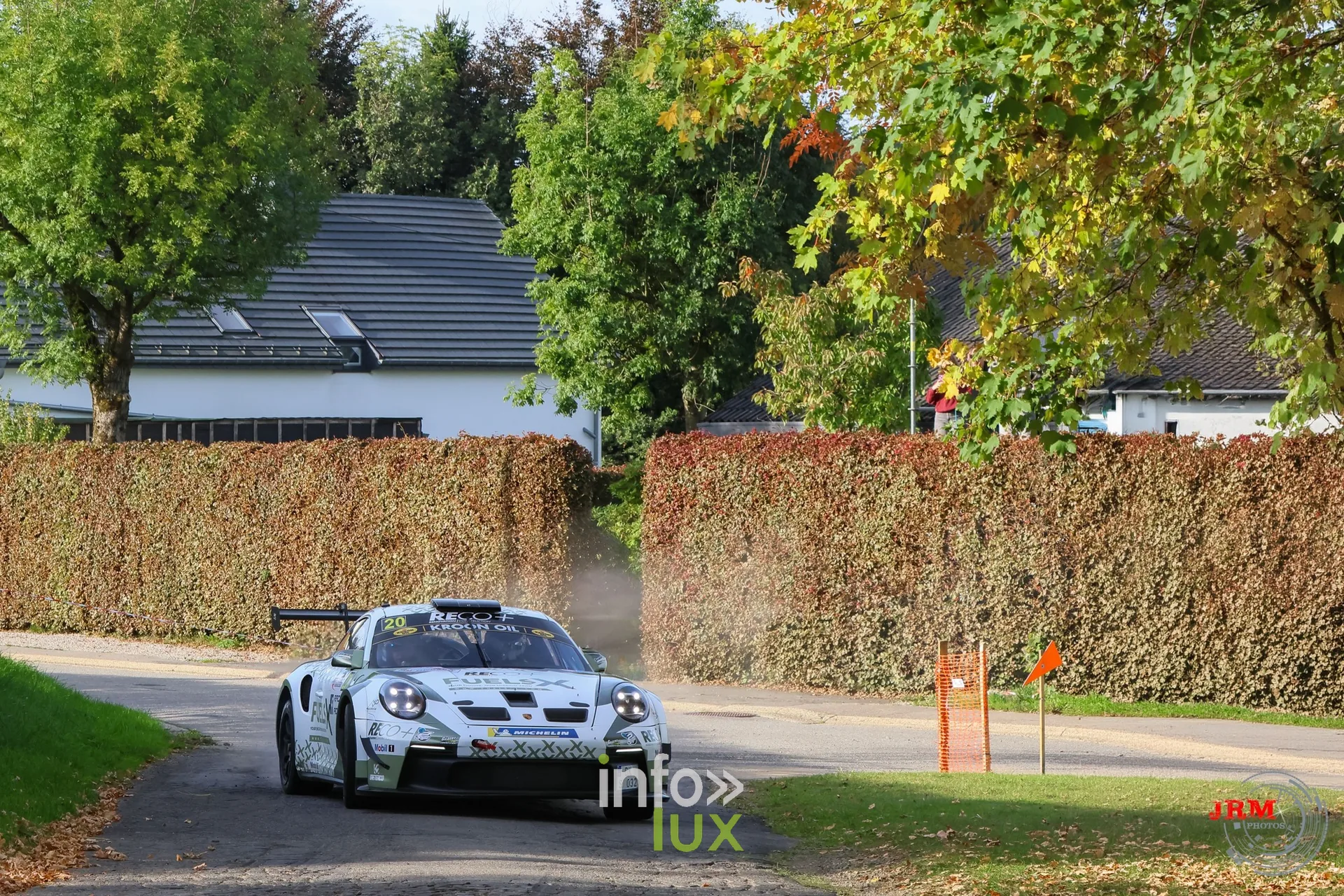 Porsche 911 GT3 de rallye blanche devant une maison blanche et une haie, East Belgian Rally 2026