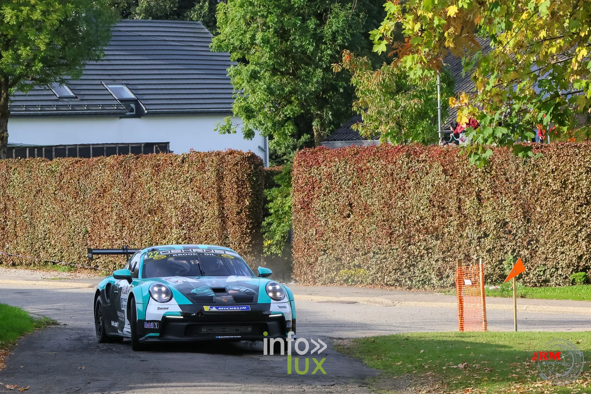 Porsche 911 GT3 de rallye turquoise devant une maison blanche et une haie, East Belgian Rally 2026