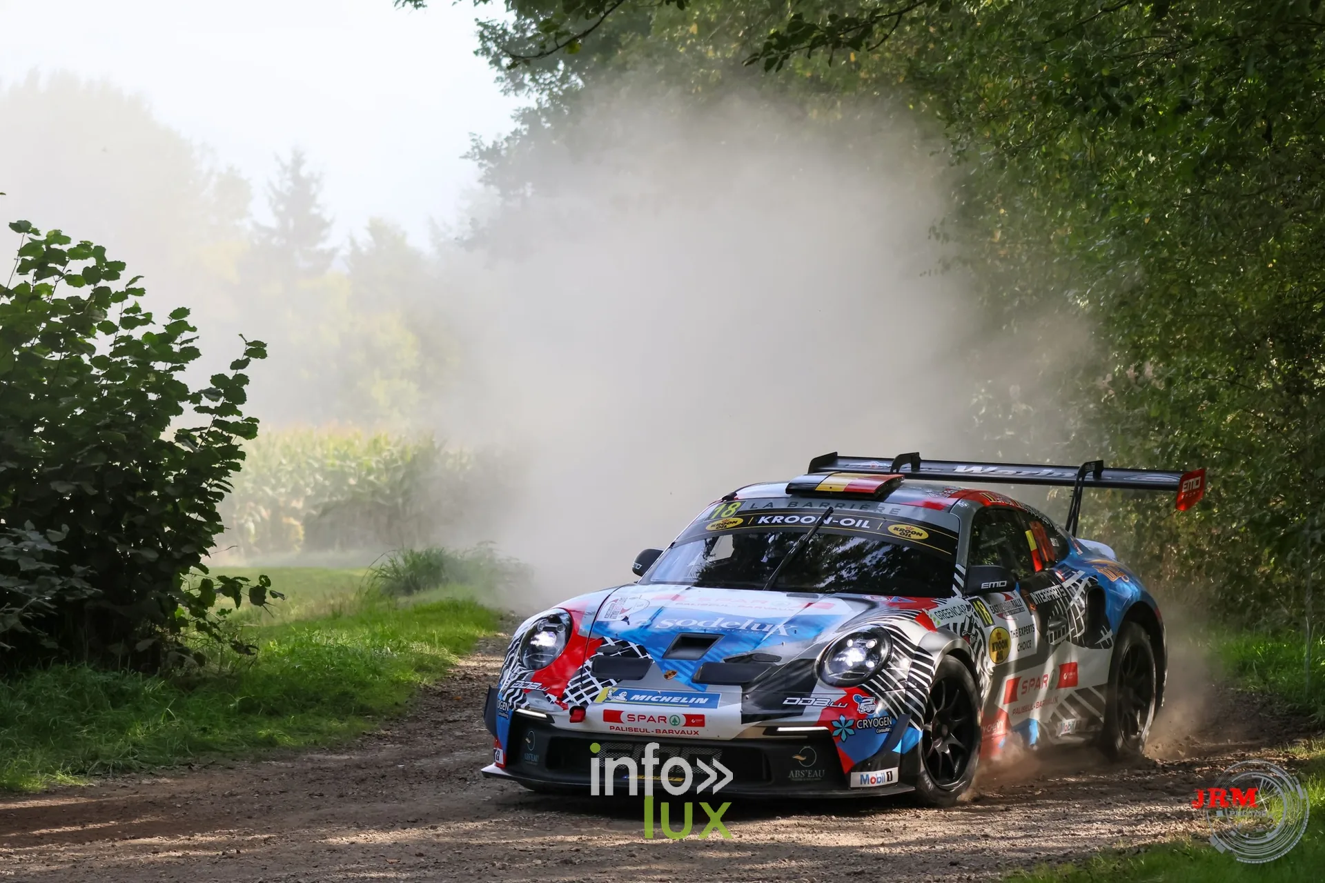 Porsche 911 GT3 de rallye blanche et bleue en dérive sur un chemin de terre, East Belgian Rally 2026