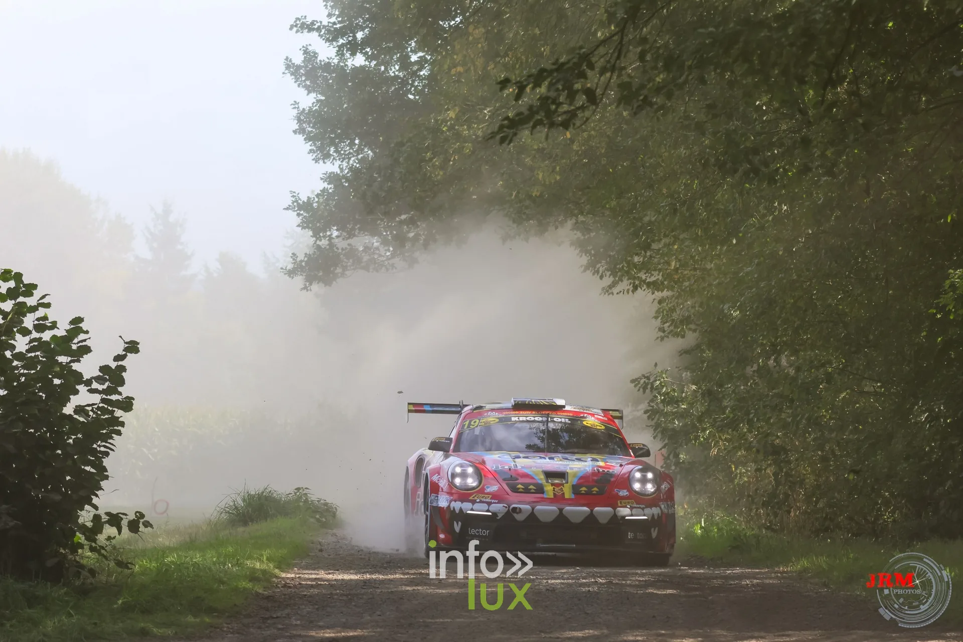Porsche 911 GT3 de rallye rouge dans la poussière sur un chemin de terre, East Belgian Rally 2026