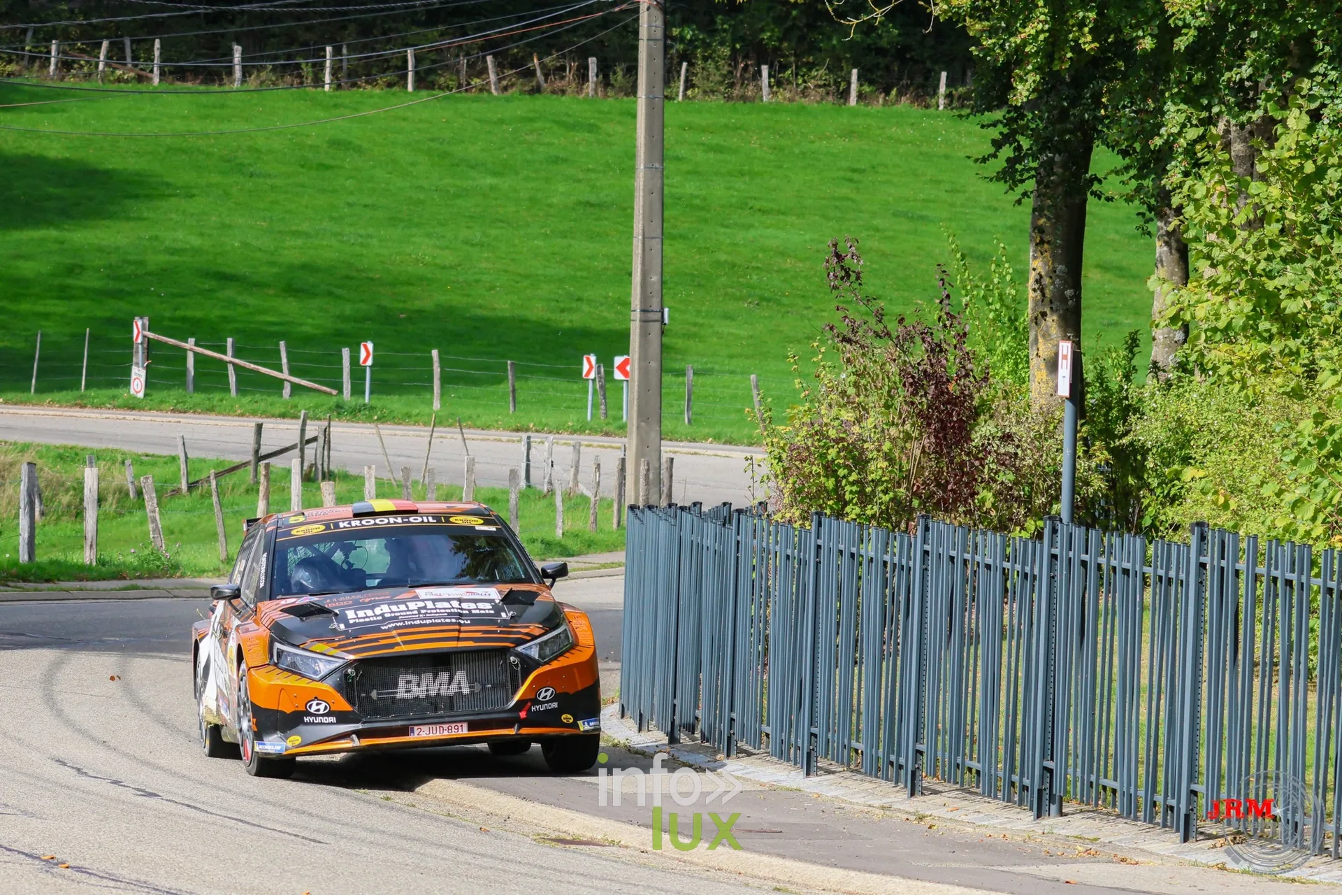 Hyundai i20 Rally2 orange et noire dans une épingle en village, East Belgian Rally 2026