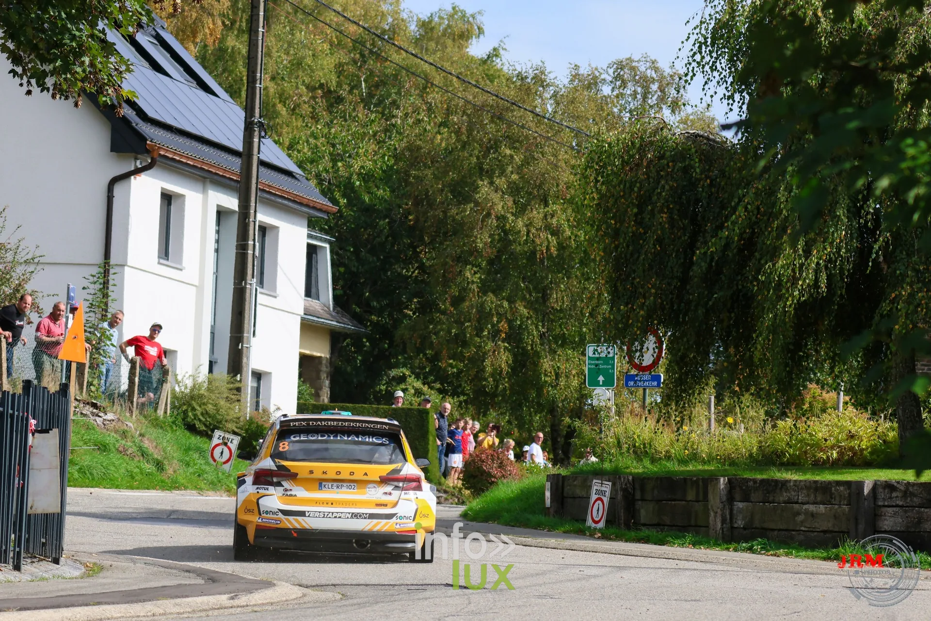 Voiture de rallye jaune, spectateurs sur le talus dans la traversée d’un village, East Belgian Rally 2026