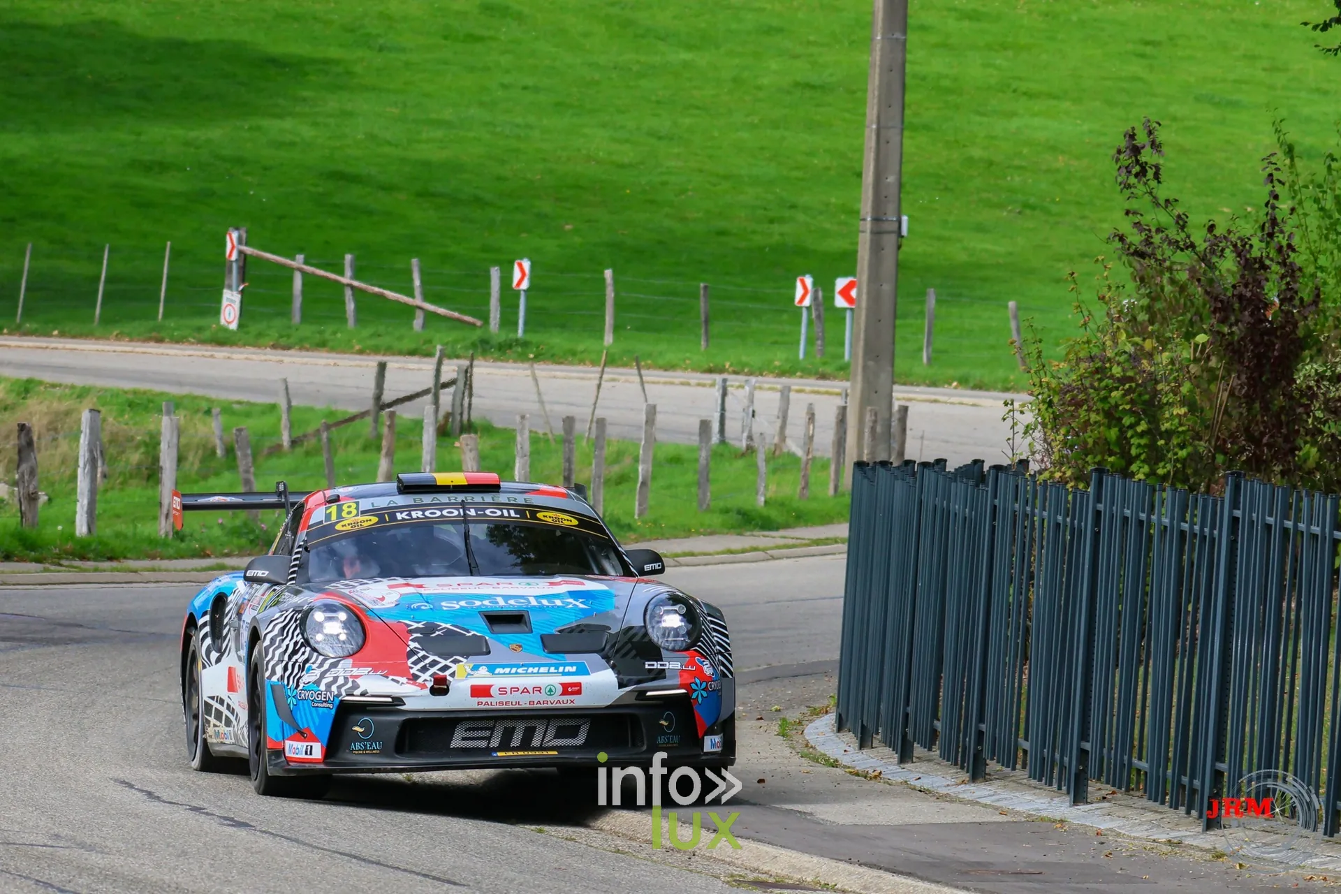 Porsche 911 GT3 de rallye bleue et blanche dans une épingle en village, East Belgian Rally 2026