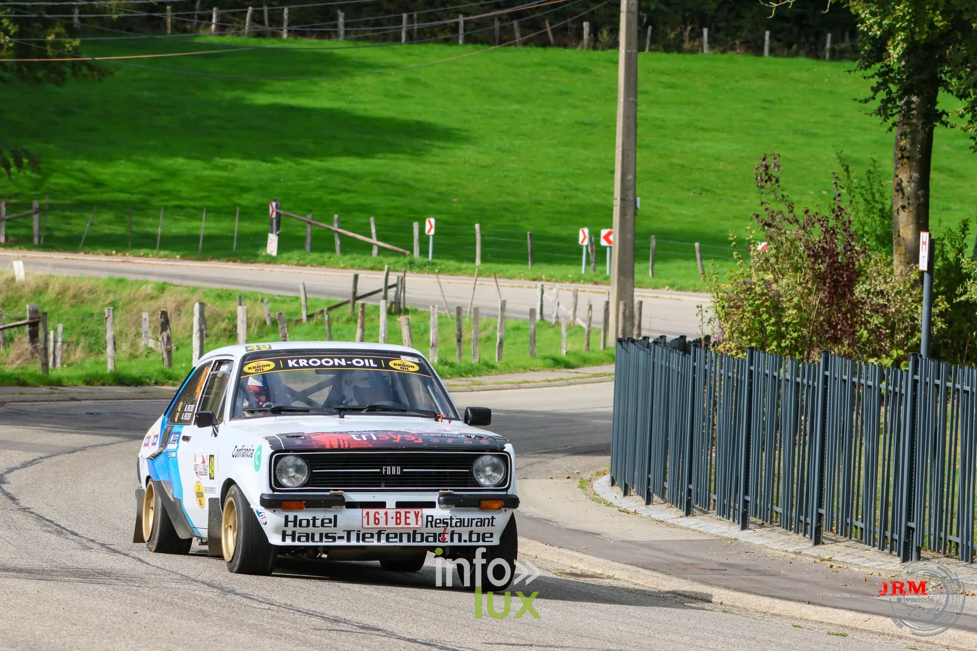 Ford Escort blanche aux couleurs d’un hôtel dans une épingle en village, East Belgian Rally 2026