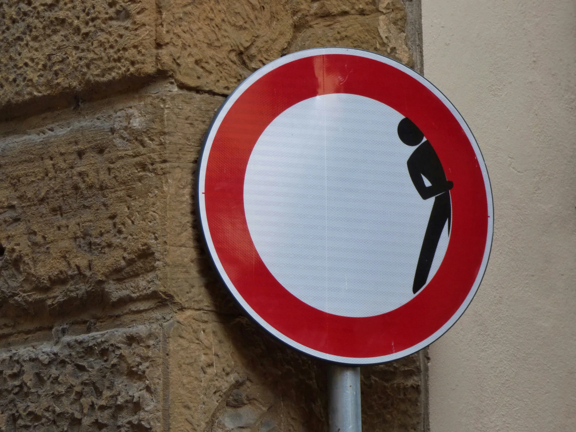 Panneau routier rond, barré de rouge, où une silhouette se détourne