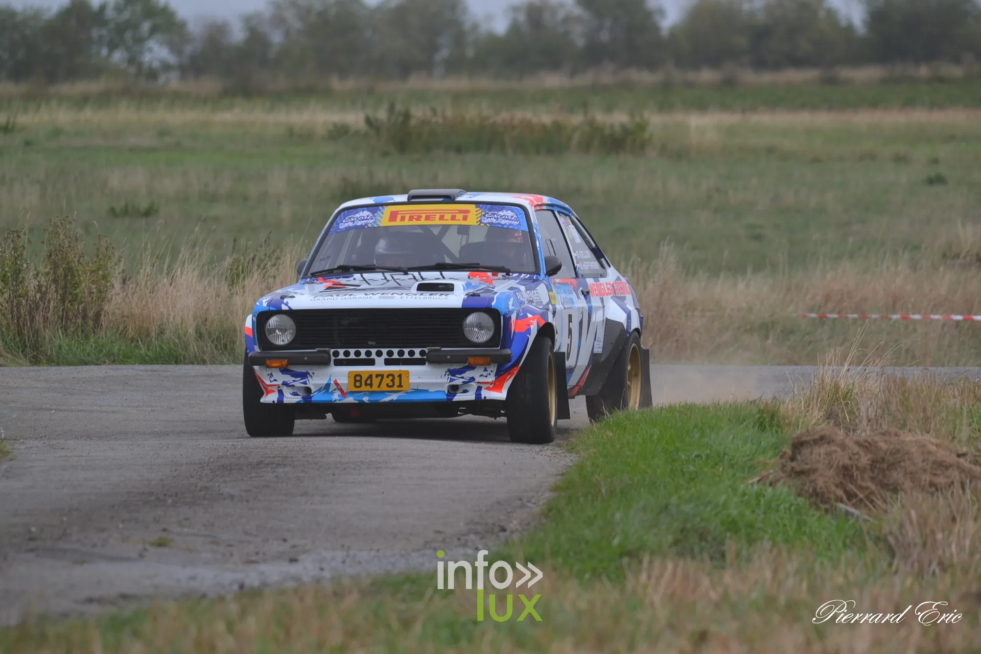 Ford Escort MkII bleu blanc rouge de Bob Kellen et Nathalie Hoffmann lancee sur une route de l Entre-Sambre-et-Meuse