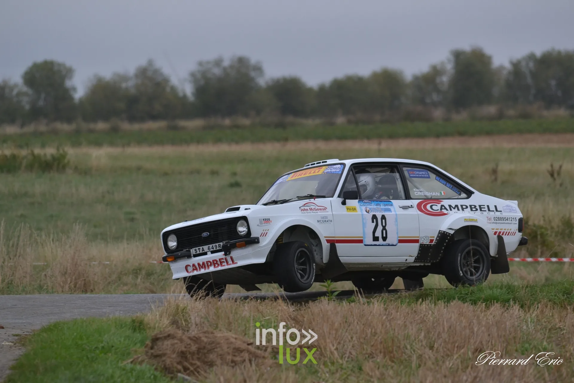 Ford Escort MkII blanche numero 28 de Declan Campbell et Kevin Creighan en glisse sur route de campagne