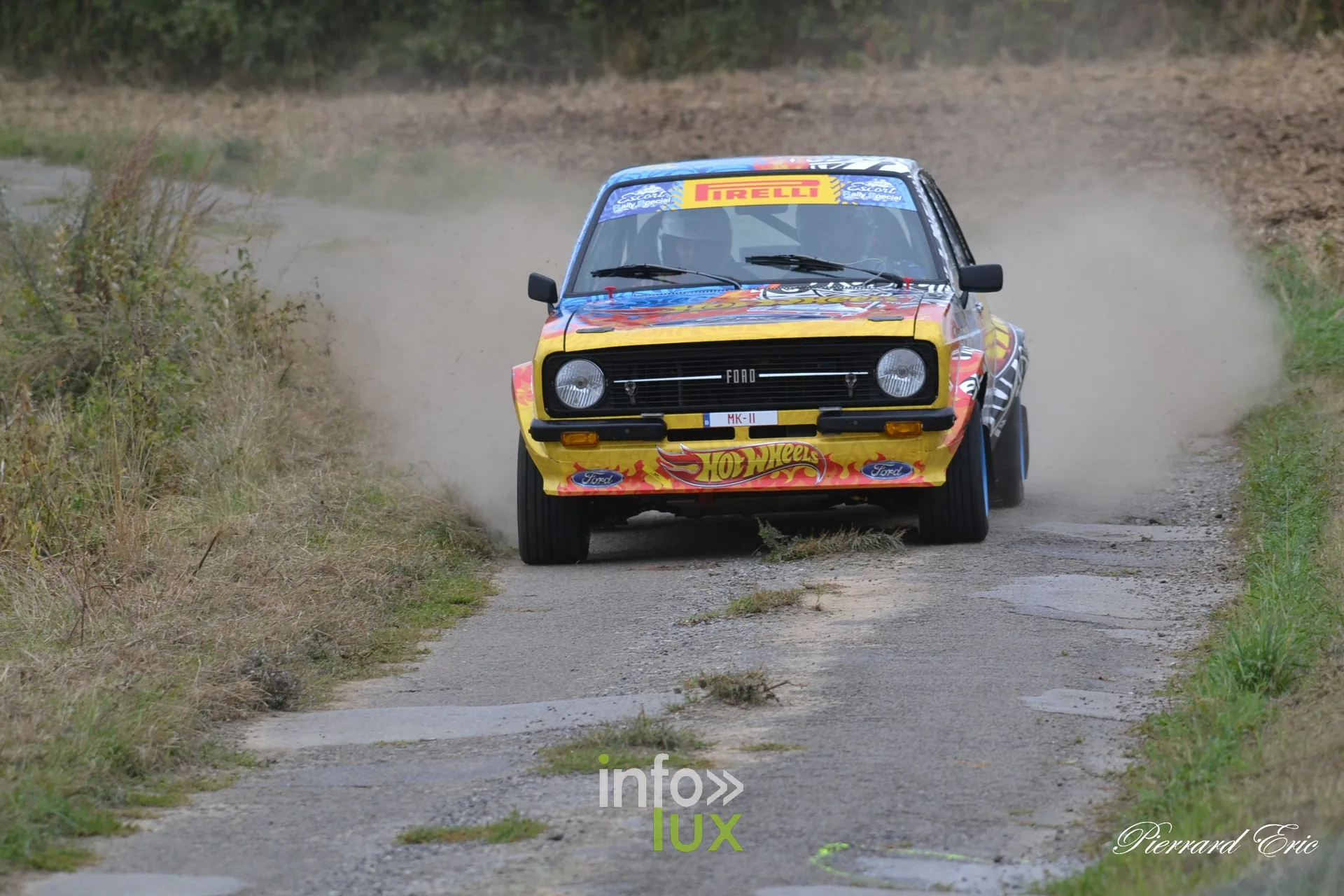 Ford Escort MkII jaune et orange Hot Wheels de Julien Elleboudt et Helene Bourdon sur une route de campagne