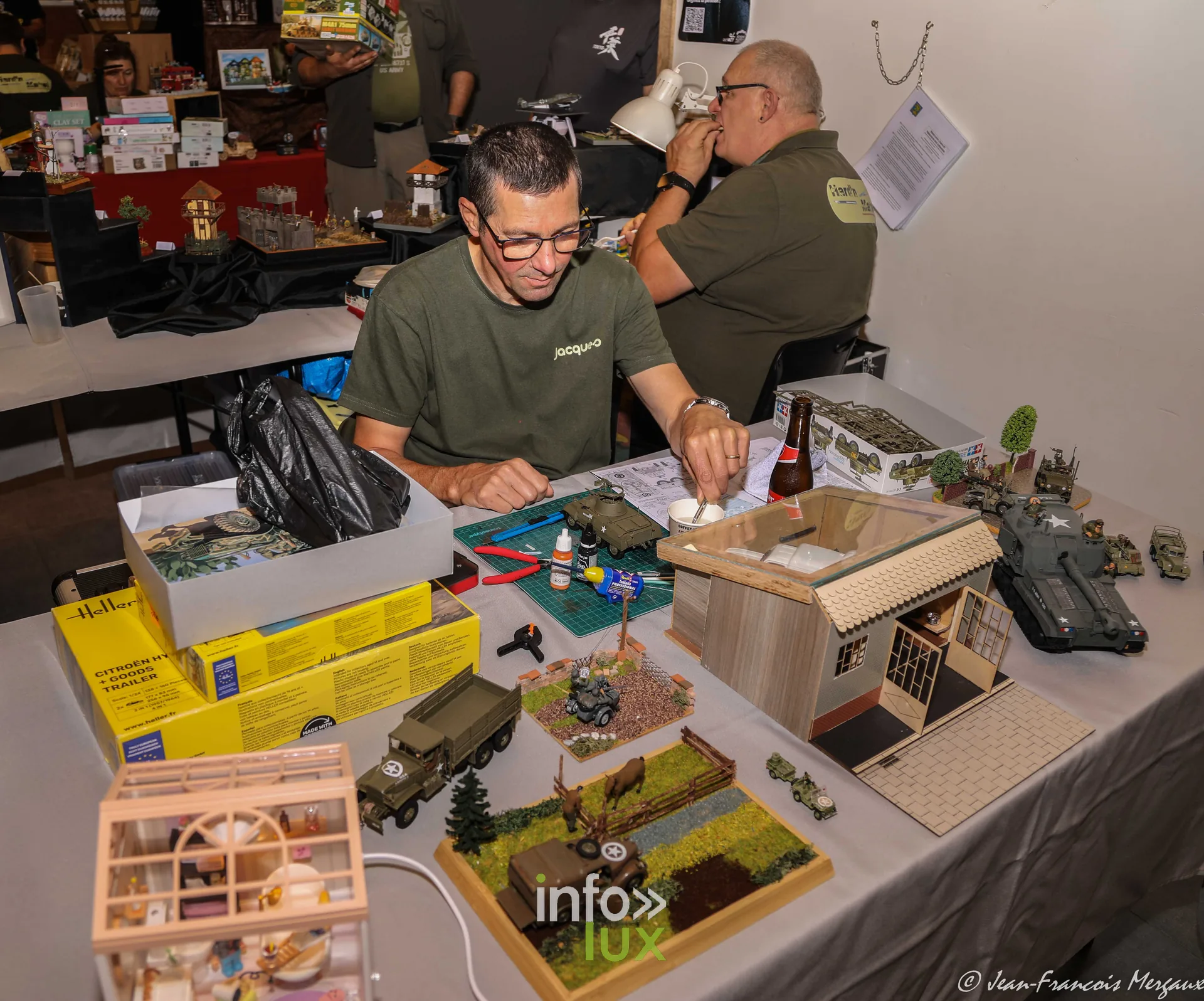 Maquettiste peignant une maison miniature en demonstration a l'expo de Neufchateau