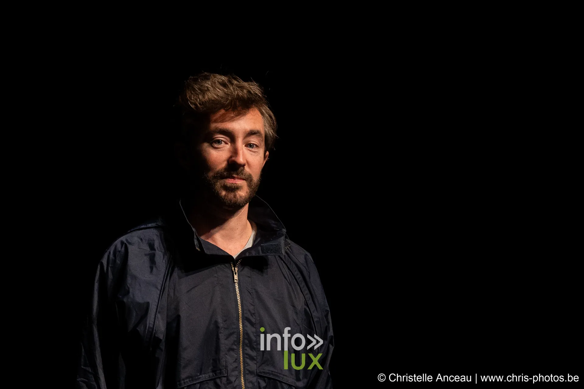 Portrait d'un interprète en veste sombre sur fond noir