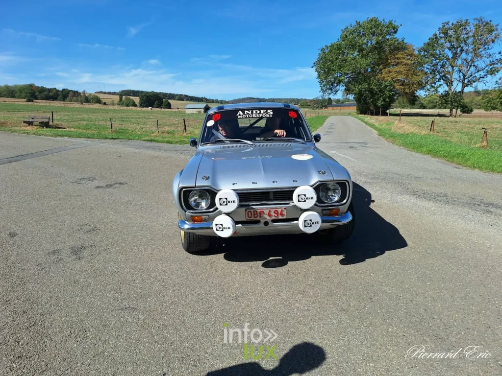 Ford Escort MkI grise en action sur une route de campagne de la Famenne