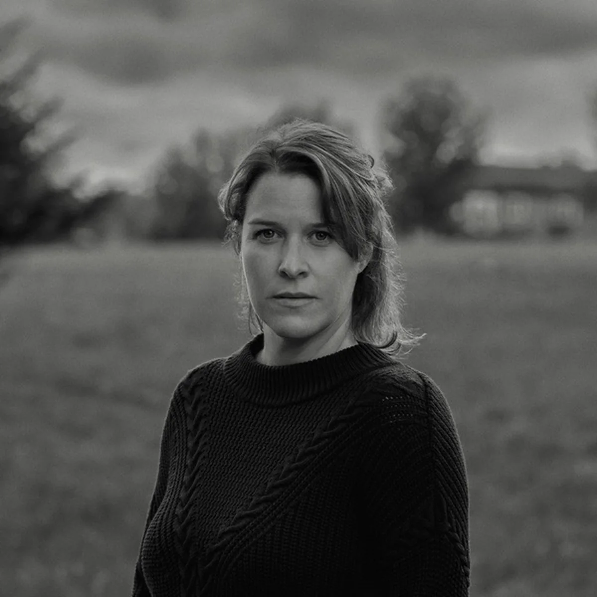 Portrait en noir et blanc de Fannie, chanteuse québécoise, dans un champ