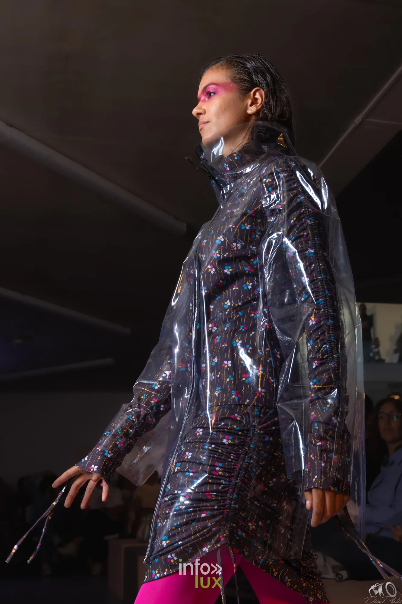 Gros plan de profil d’un mannequin en manteau transparent à pois, maquillage rose sur les paupières