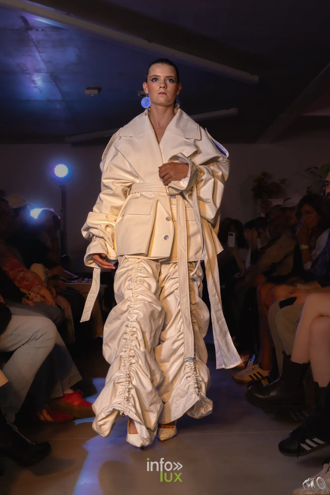 Mannequin en ensemble blanc cassé froncé et ruché, veste et pantalon volumineux, sur le podium