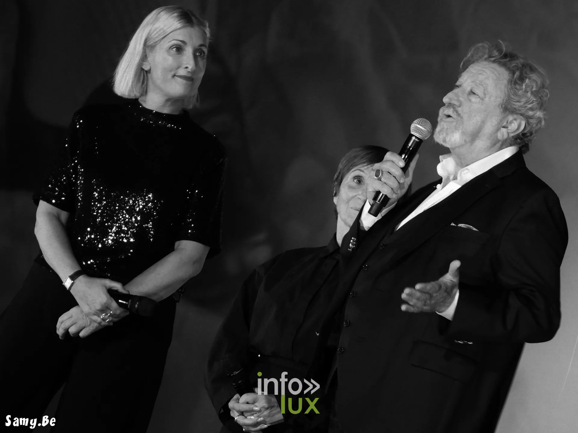Robert Guédiguian au micro, Ariane Ascaride et Charlotte Lipinska à ses côtés, en noir et blanc