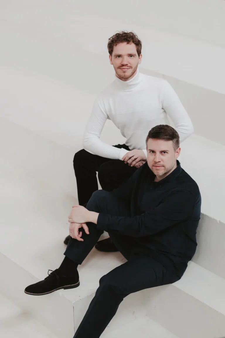Les ténors Pierre Derhet et Maxime Melnik assis sur un escalier blanc