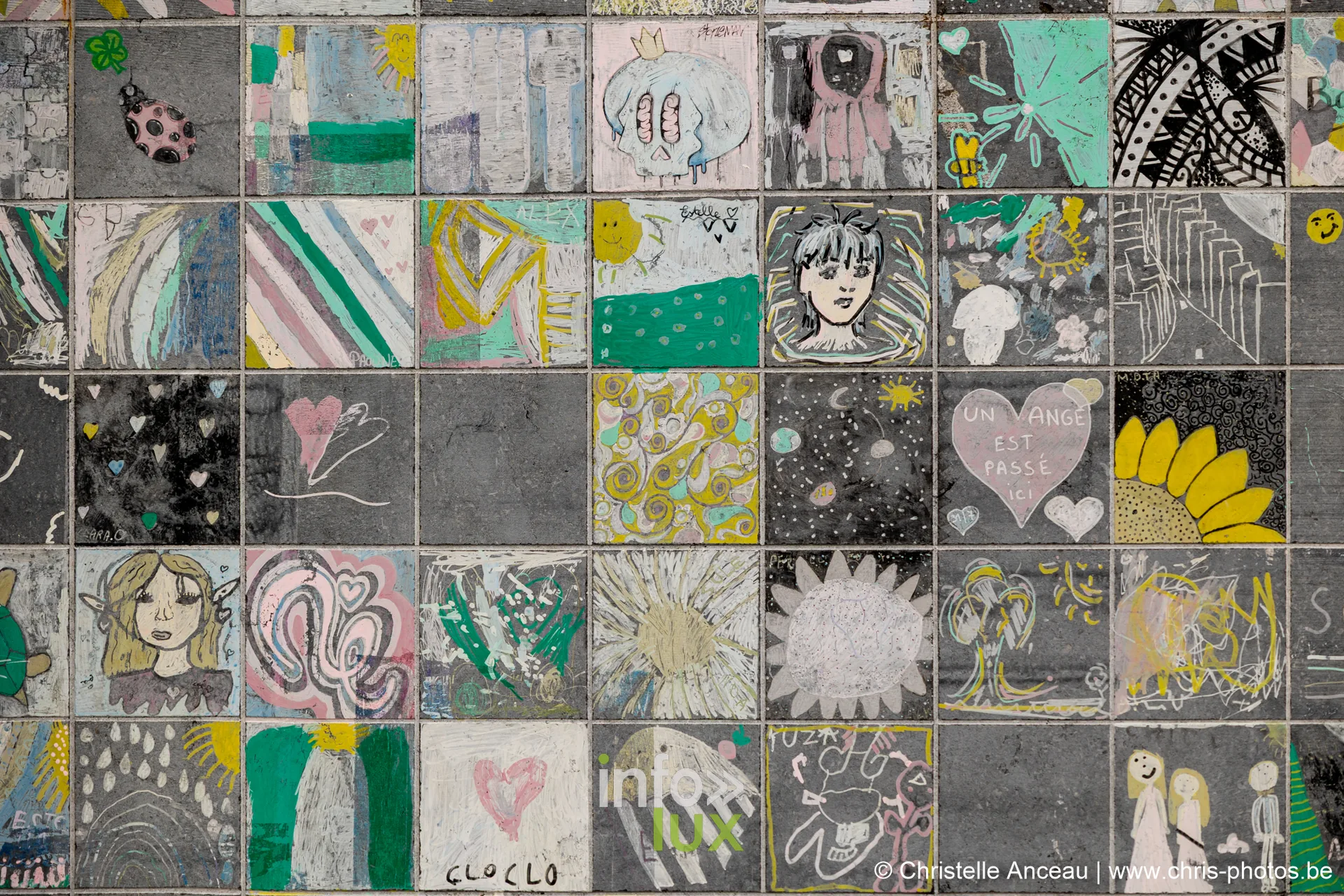 Mur de carreaux de pierre couverts de dessins colorés réalisés par le public