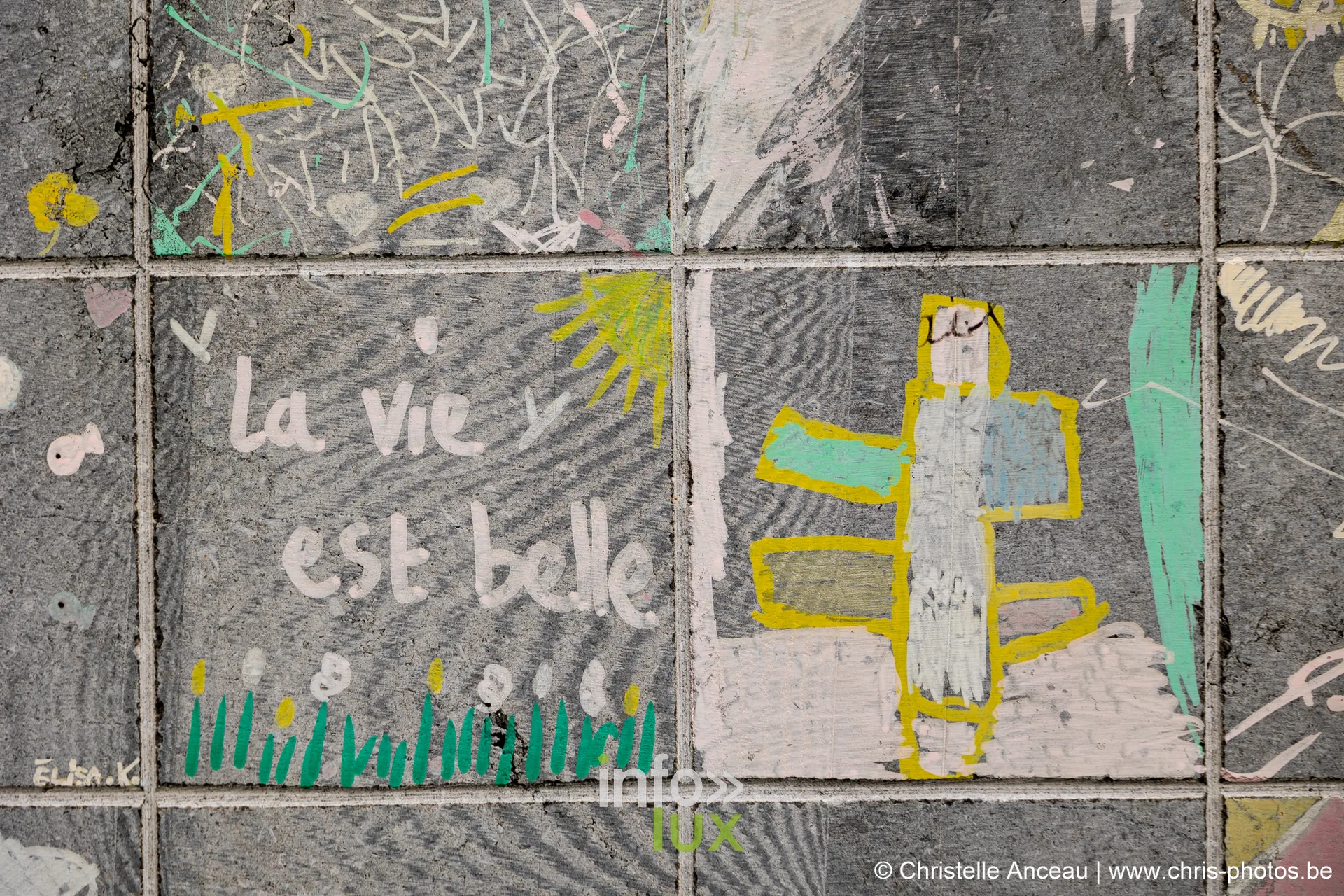 Détail de l'œuvre collaborative : « la vie est belle » tracé sur la pierre