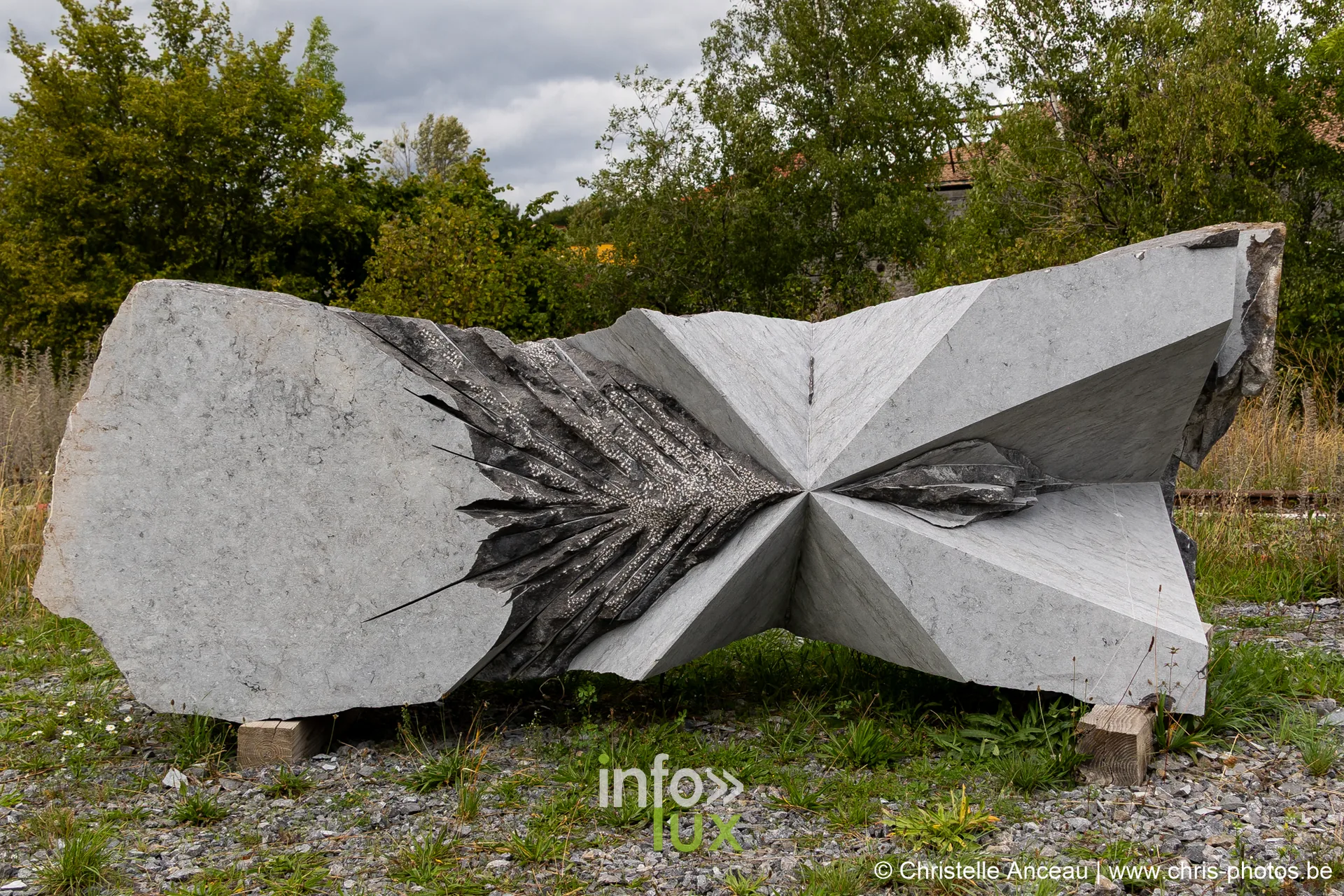Sculpture monumentale horizontale en pierre bleue, aux facettes taillées