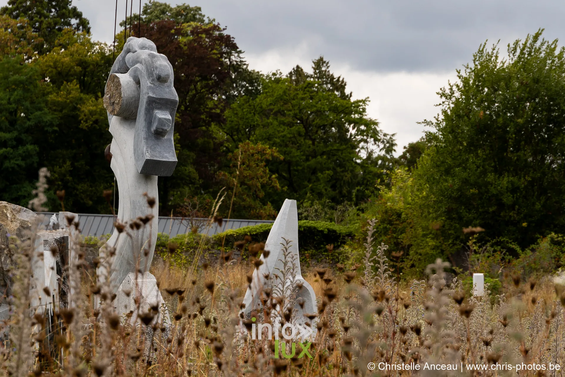 Sculptures dressées dans un pré, au milieu des herbes hautes