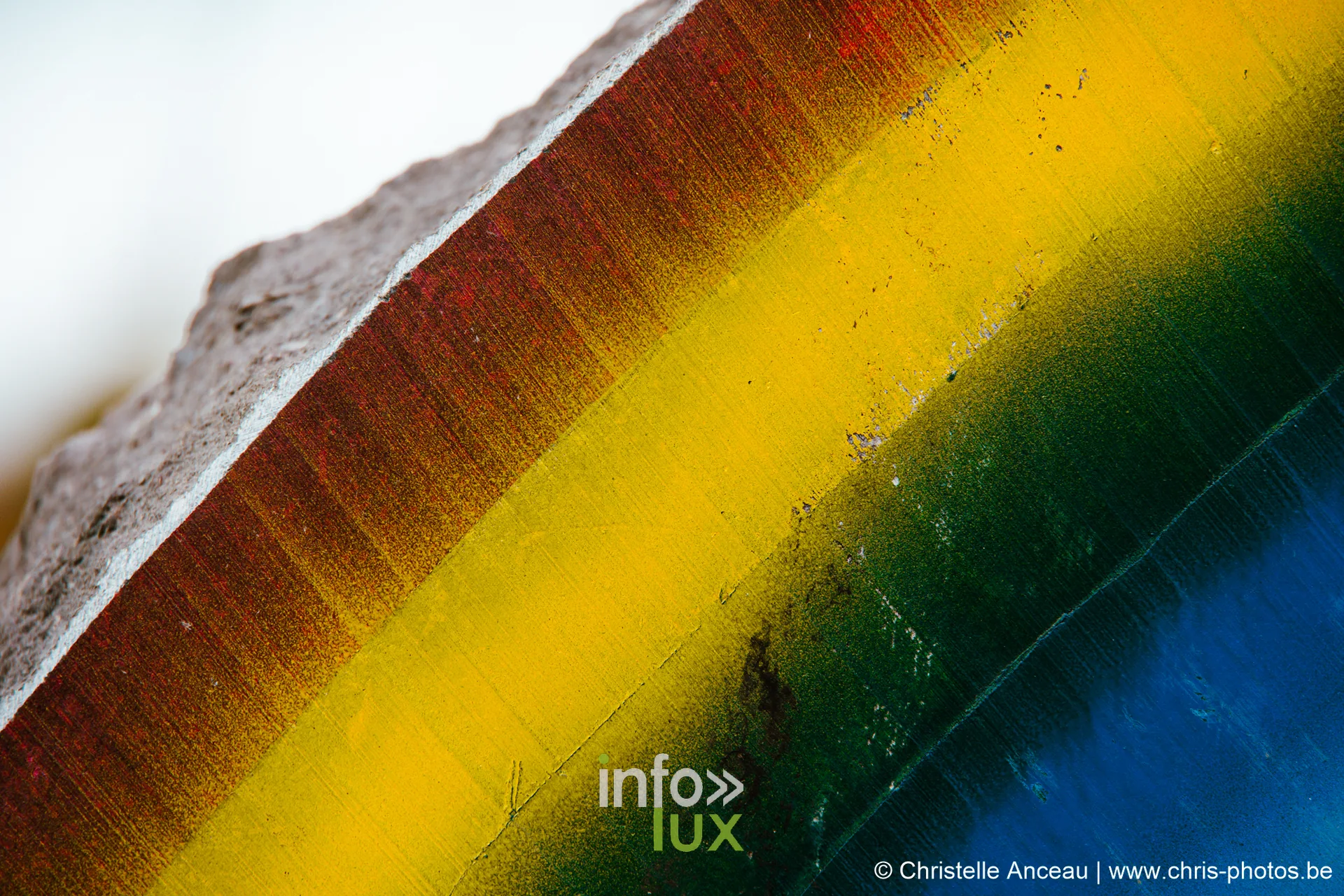 Détail coloré d'une œuvre : bandes rouge, jaune, verte et bleue sur la pierre
