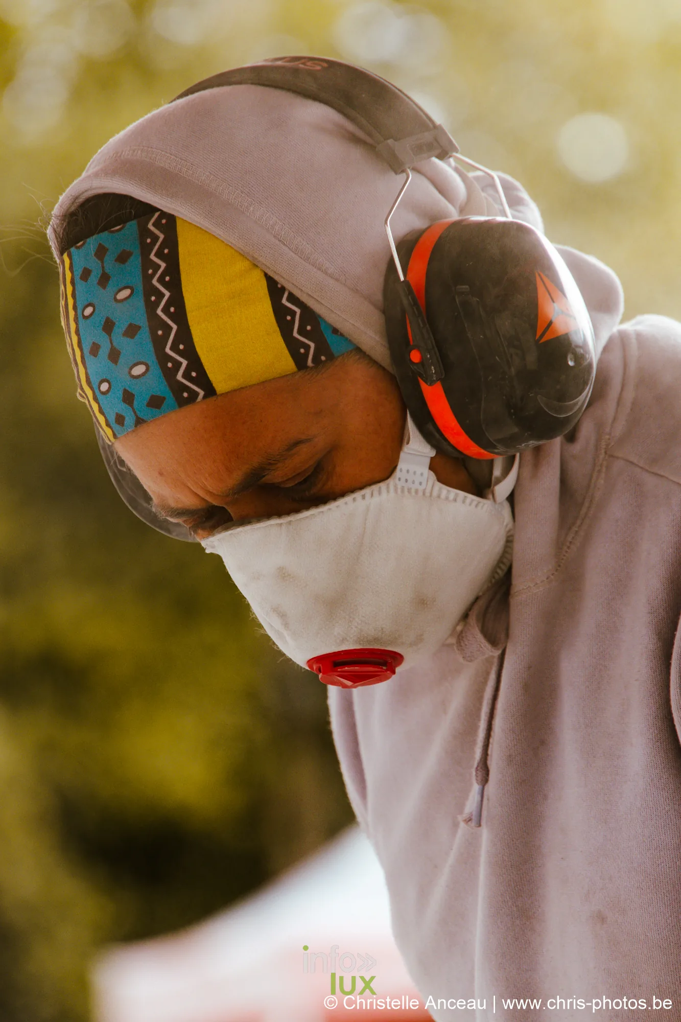 Portrait d'une sculptrice, masque coloré et casque antibruit relevé