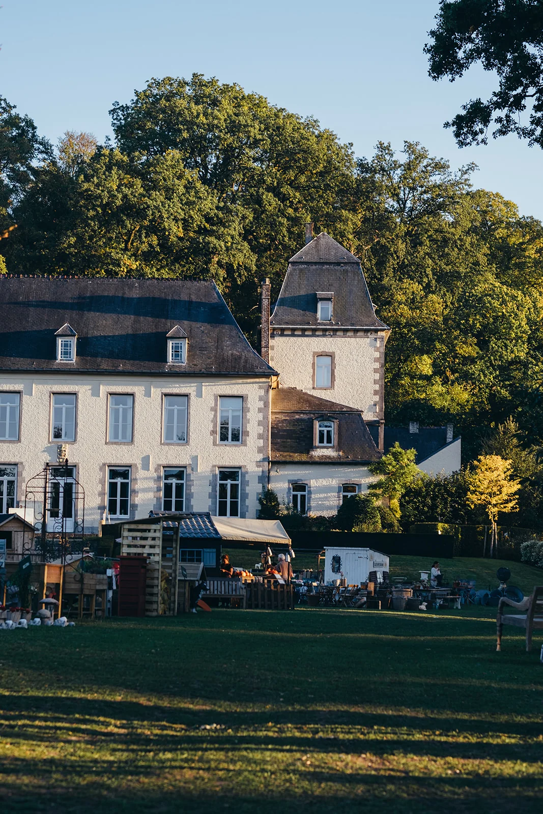 Le château de l’ancienne abbaye d’Aywiers et les stands de la fête en fin de journée
