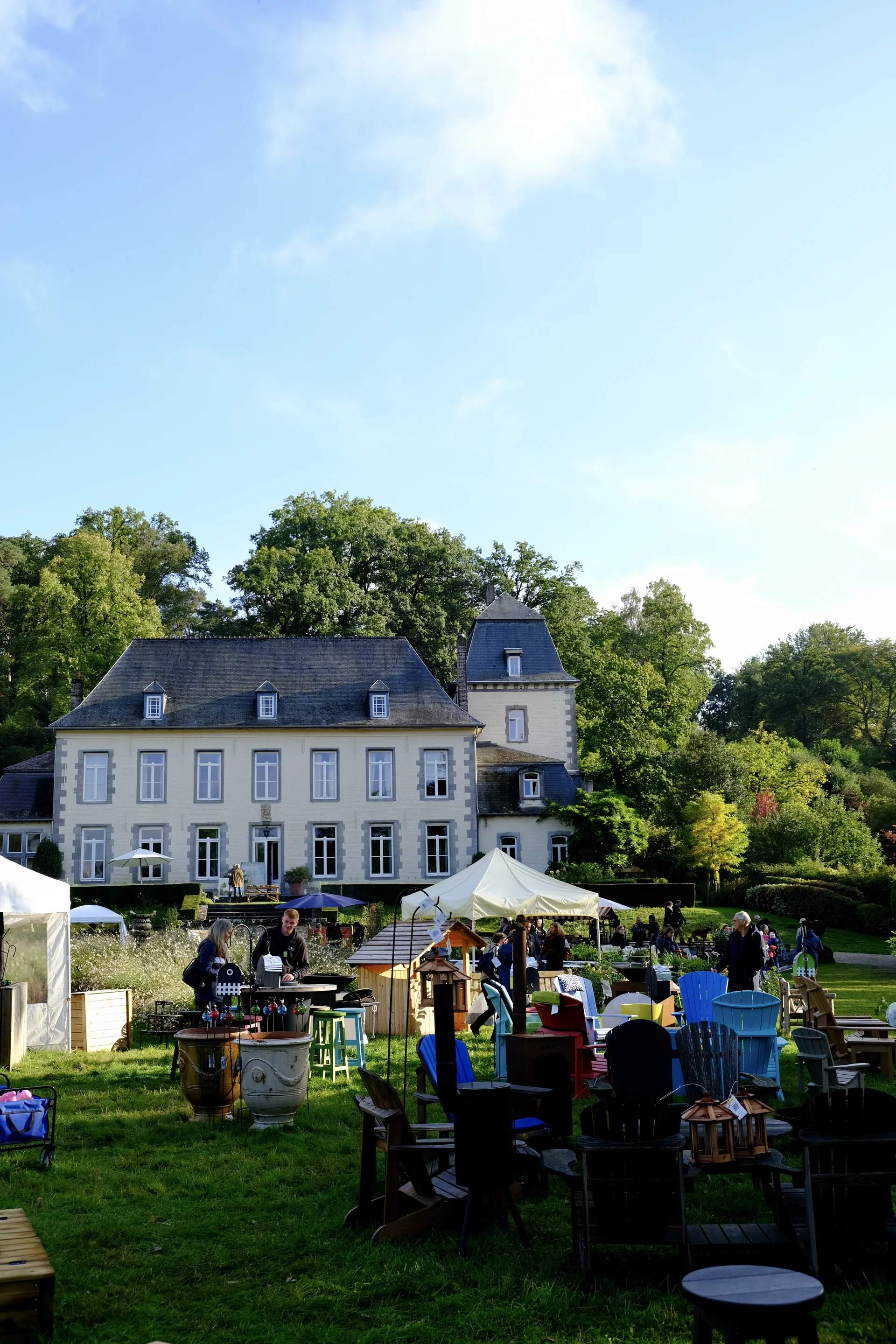 Stands et mobilier de jardin sur la pelouse devant le château d’Aywiers
