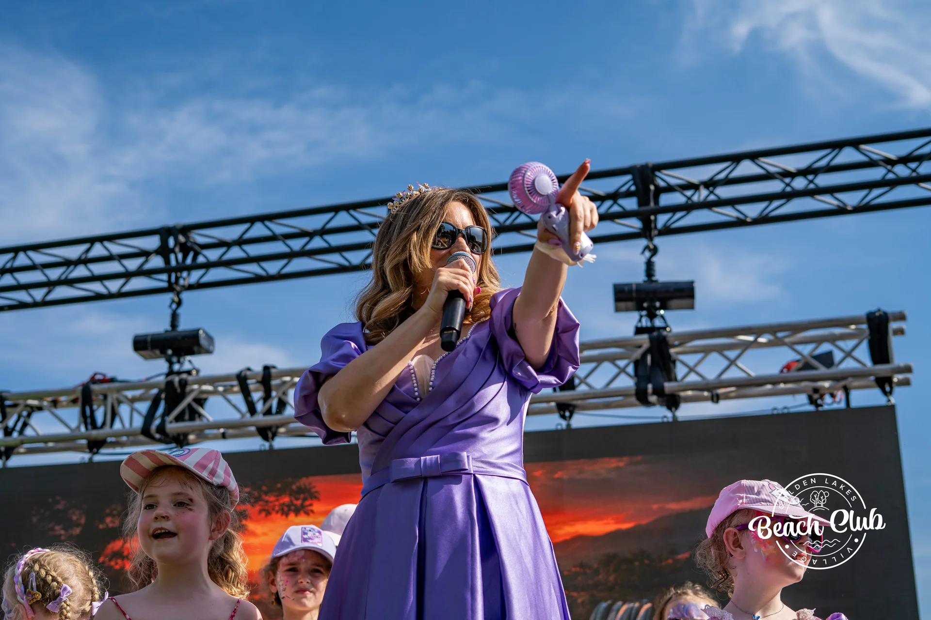 Chanteuse au micro devant le public sur la scene exterieure au bord du lac