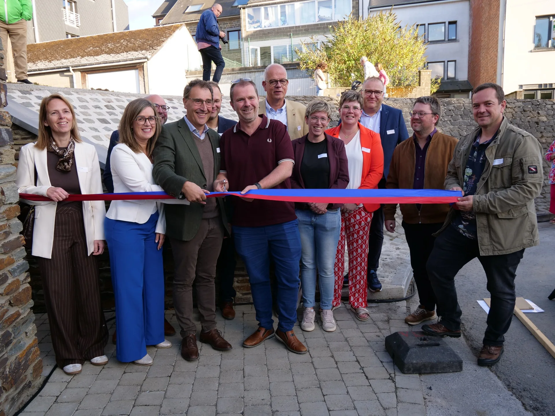 Élus et partenaires tiennent le ruban tricolore lors de l’inauguration du Hall Relais Agricole à Bastogne