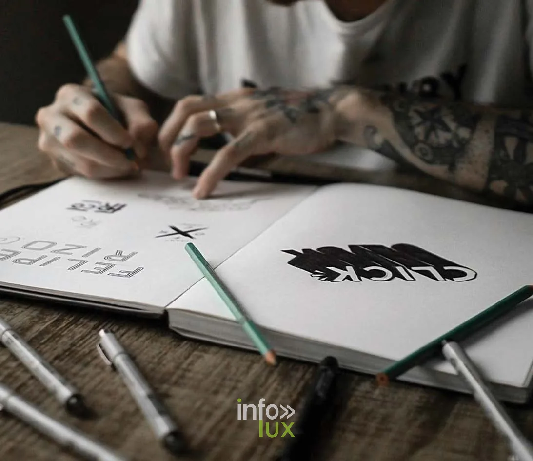 Mains dessinant un lettrage dans un carnet de croquis, cours de graphisme de la HEAJ à Namur